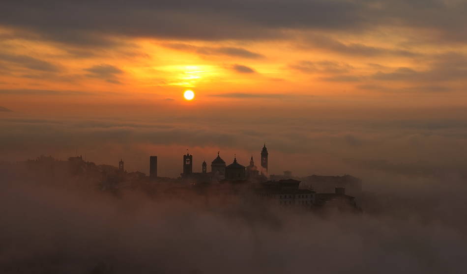 Alba su Bergamo avvolta nella nebbia